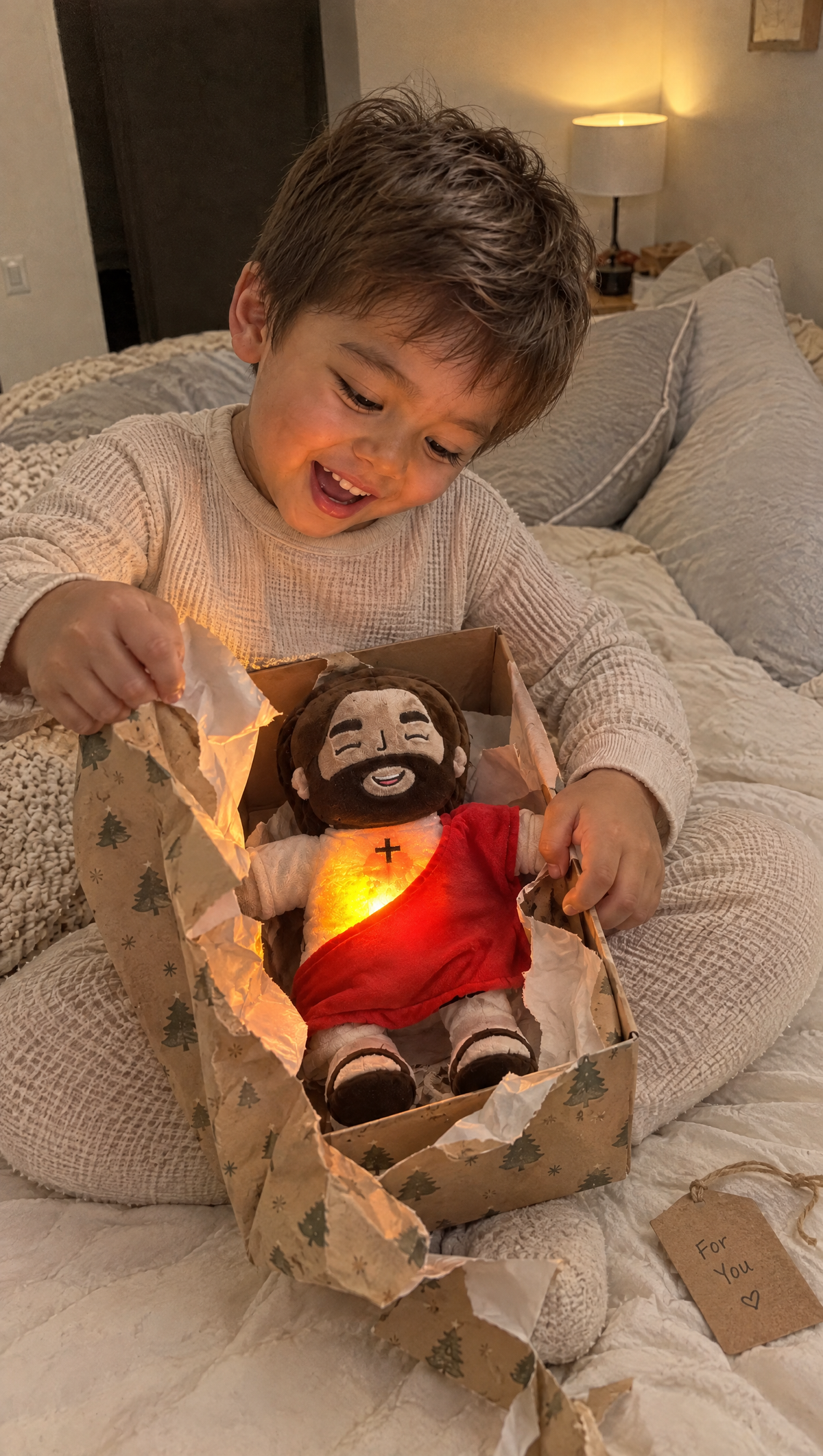 Happy boy opening a gift with the glowing Jesus plush inside
